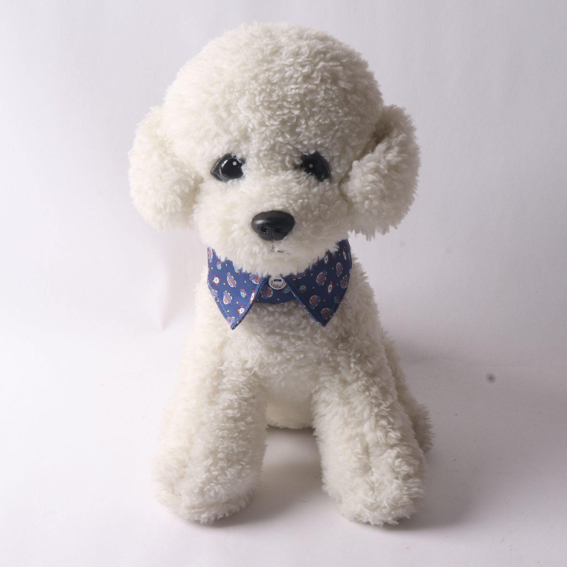 White stuffed dog toy with a blue bow tie on a white background
